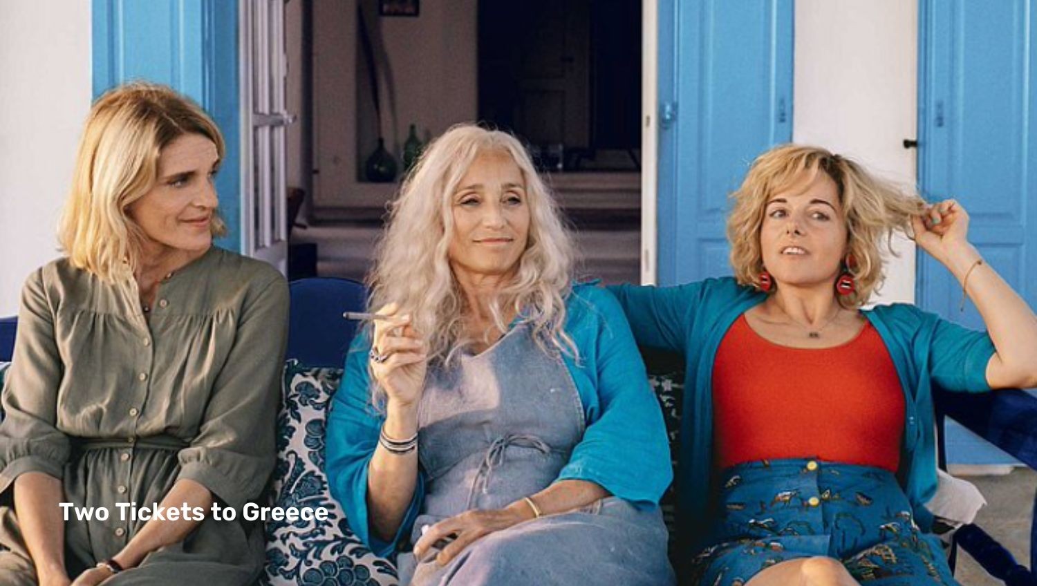 Three woman sitting outside greek house