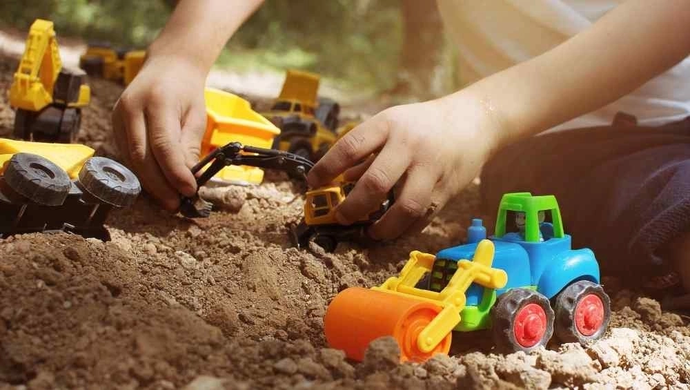 Child playing in sand with diggers