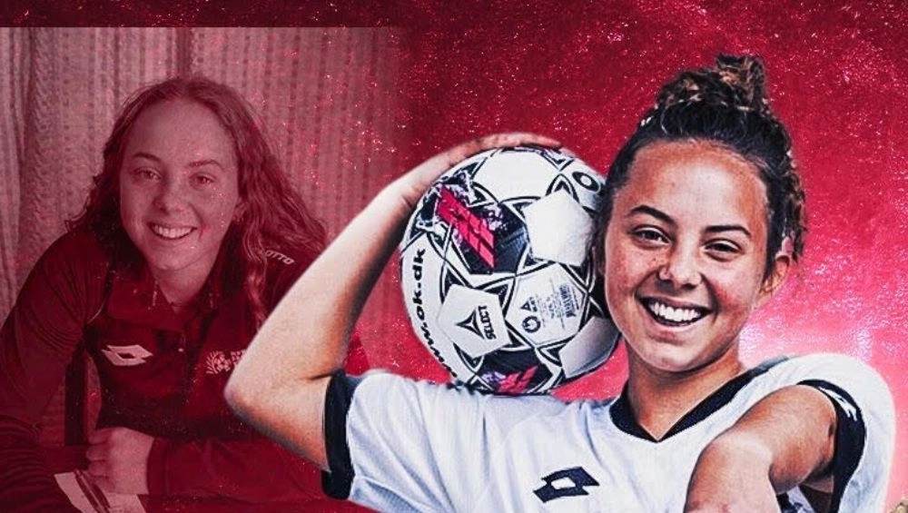 Young woman holding soccer ball on shoulder