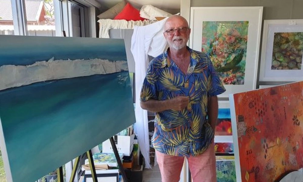 Michael Harrison, Artist standing beside two paintings