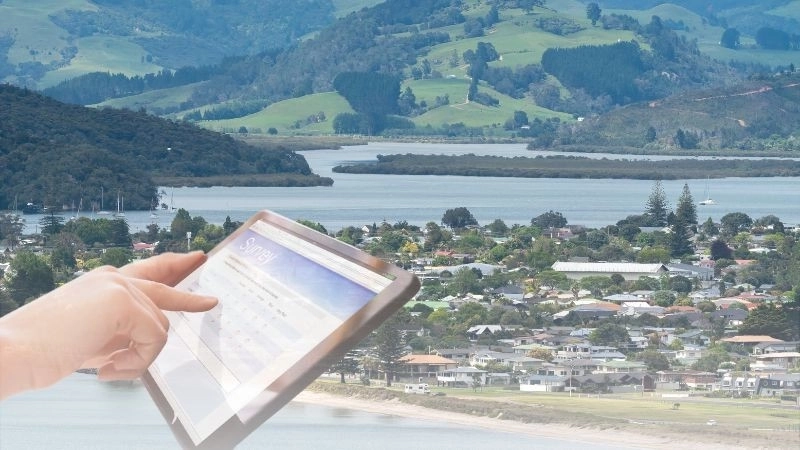 Person completing survey with Whitianga in background