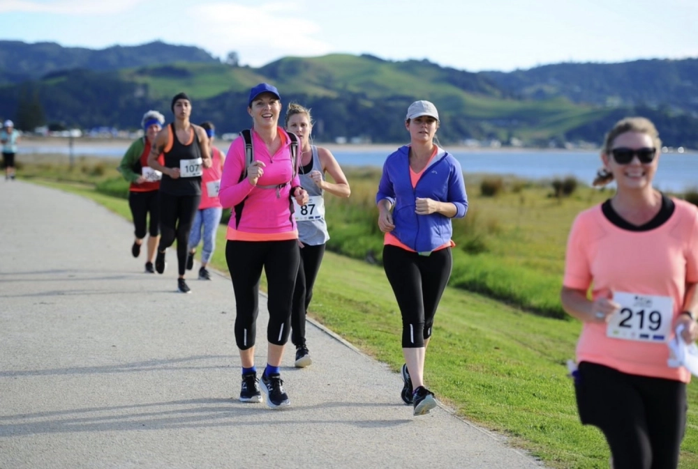 Women running along foreshore
