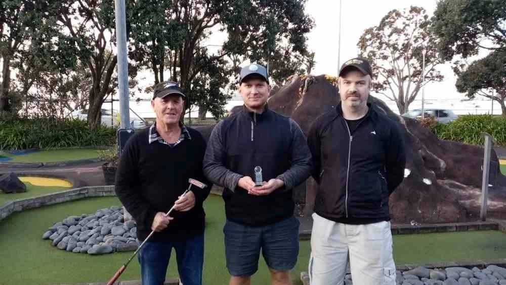 Three men on mini gold course