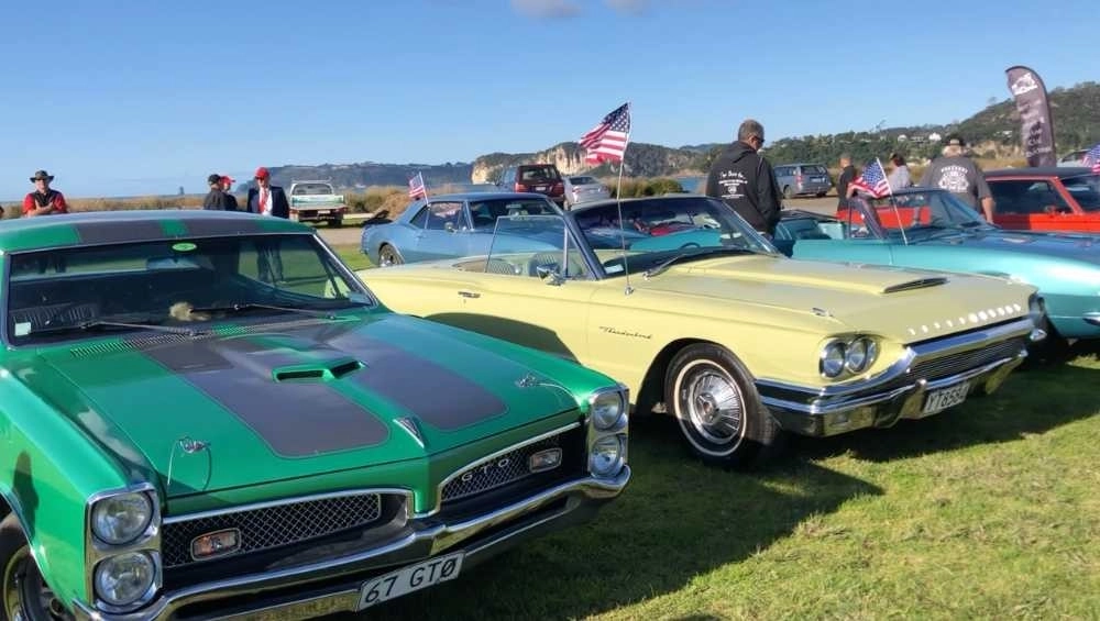 Classic American Muscle cars parked up on grass