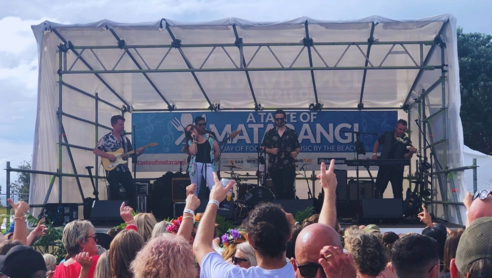 Crowd dancing at festival in front of stage