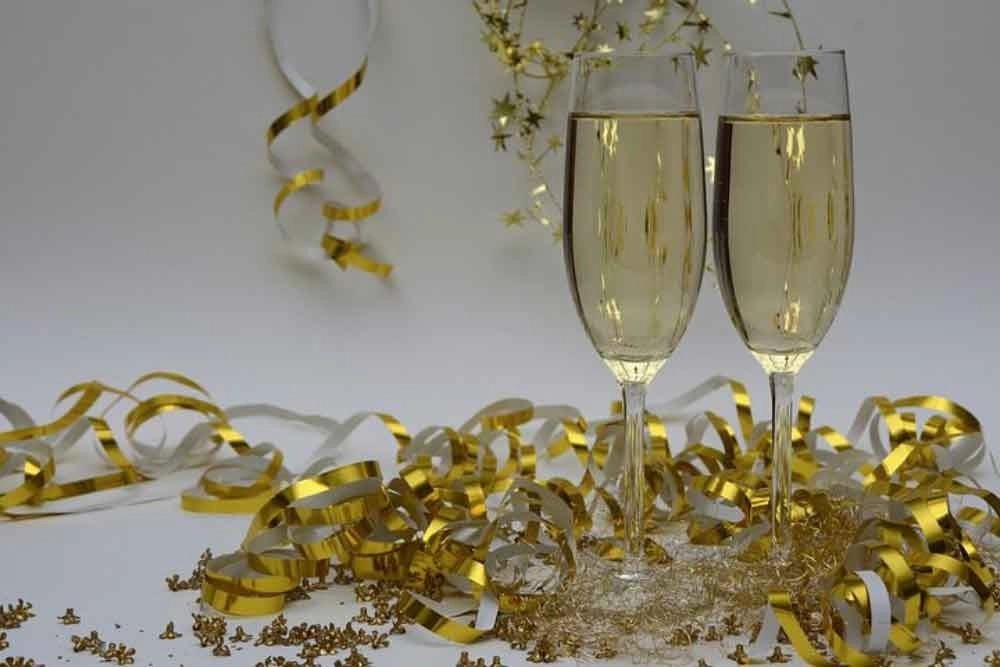 Two wine glasses with gold decorations on table