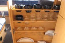 Clever storage solutions in and easy access within campervan kitchen for cups, glasses and cups
