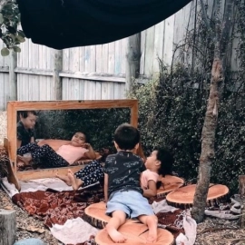 Children outside playing beside mirror