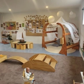 inside under 2s room, wooden ramp, cubby corner