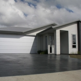 House with oxide black concrete driveway