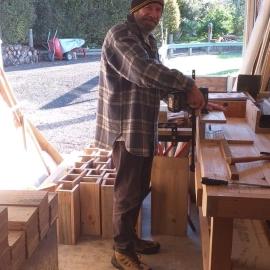 Man at workbench making rat traps