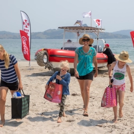 Family taking delivery of groceries on beach