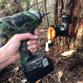 Hand holding drill installing trap