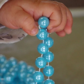 Child holding blue beads