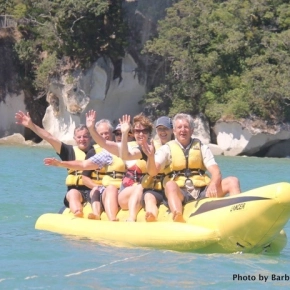 People waving on yellow banana boat