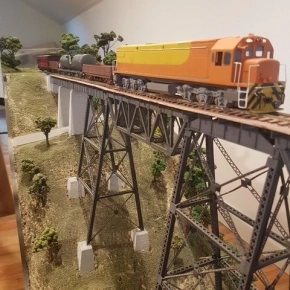 Orange and yellow train on bridge