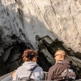 couple looking at rock wall in a boat